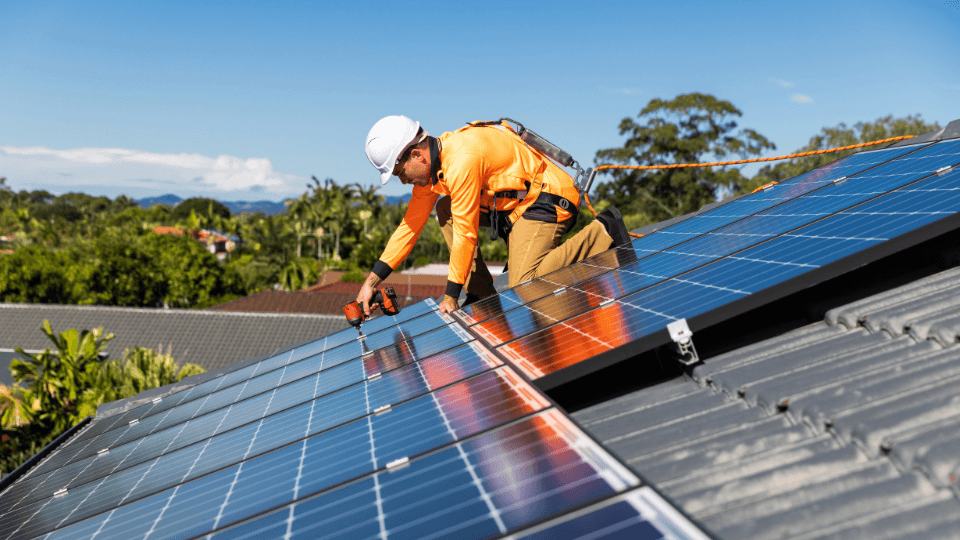 Monteur plaatst zonnepanelen op een dak
